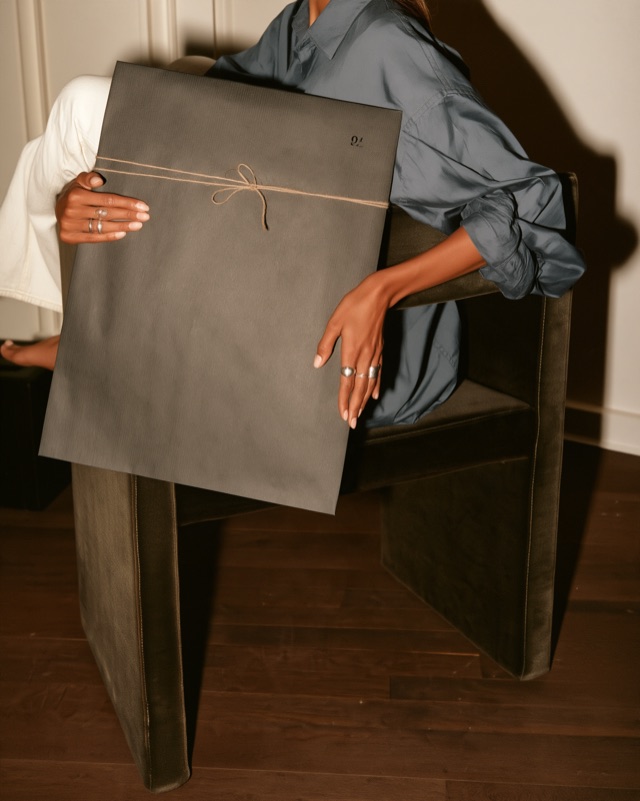The whole flat parcel tied with string, held in someone's lap