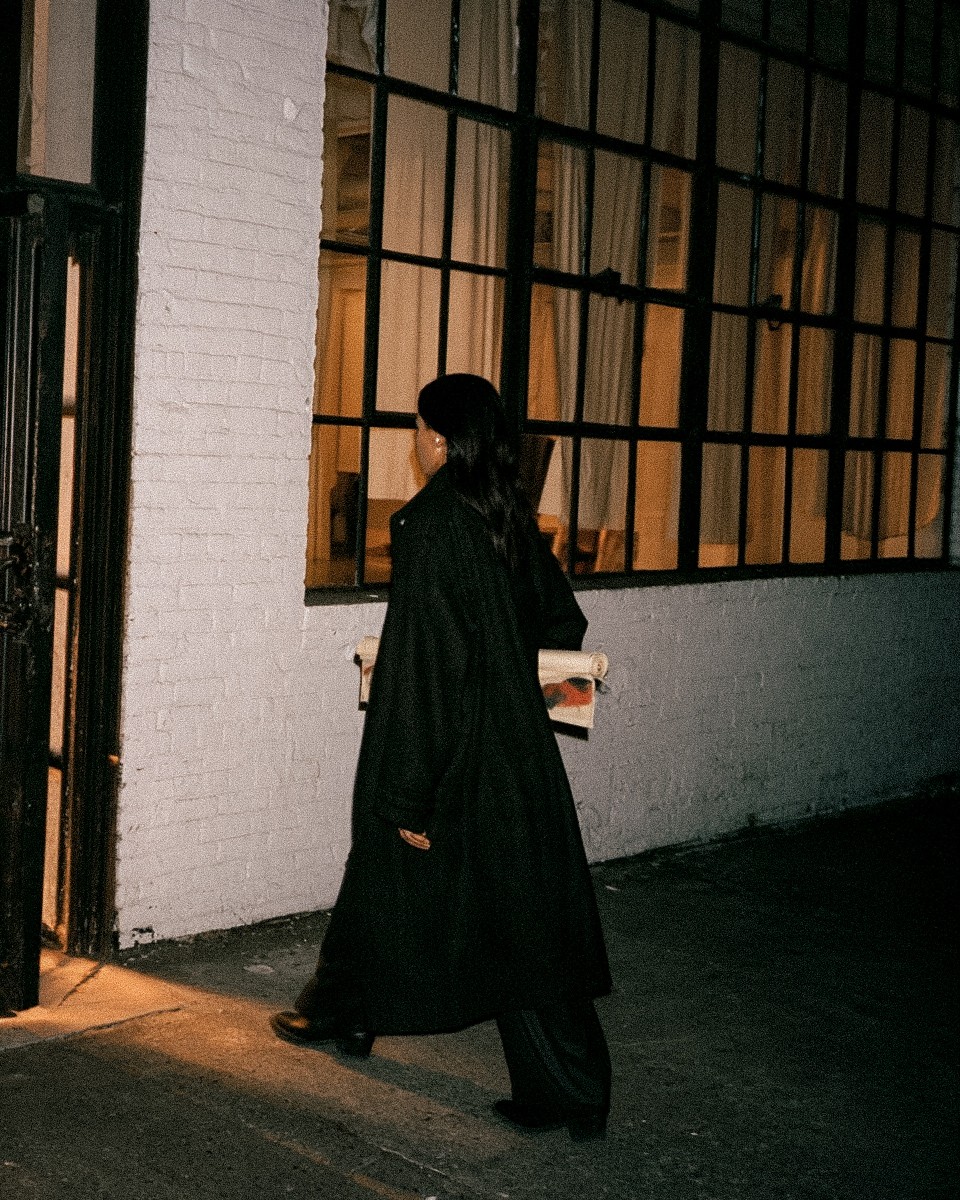 A woman leaving with her rolled length under her arm after a painting evening in London