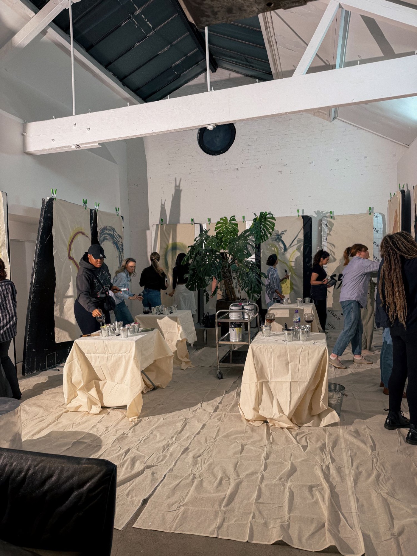The room at nine: painted lengths of cloth hung around the walls, guests standing among them